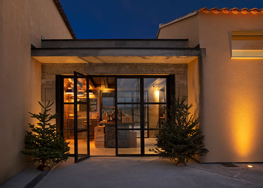 The Domaine des Jeanne winery and tasting room in Oppède, lit up at dusk