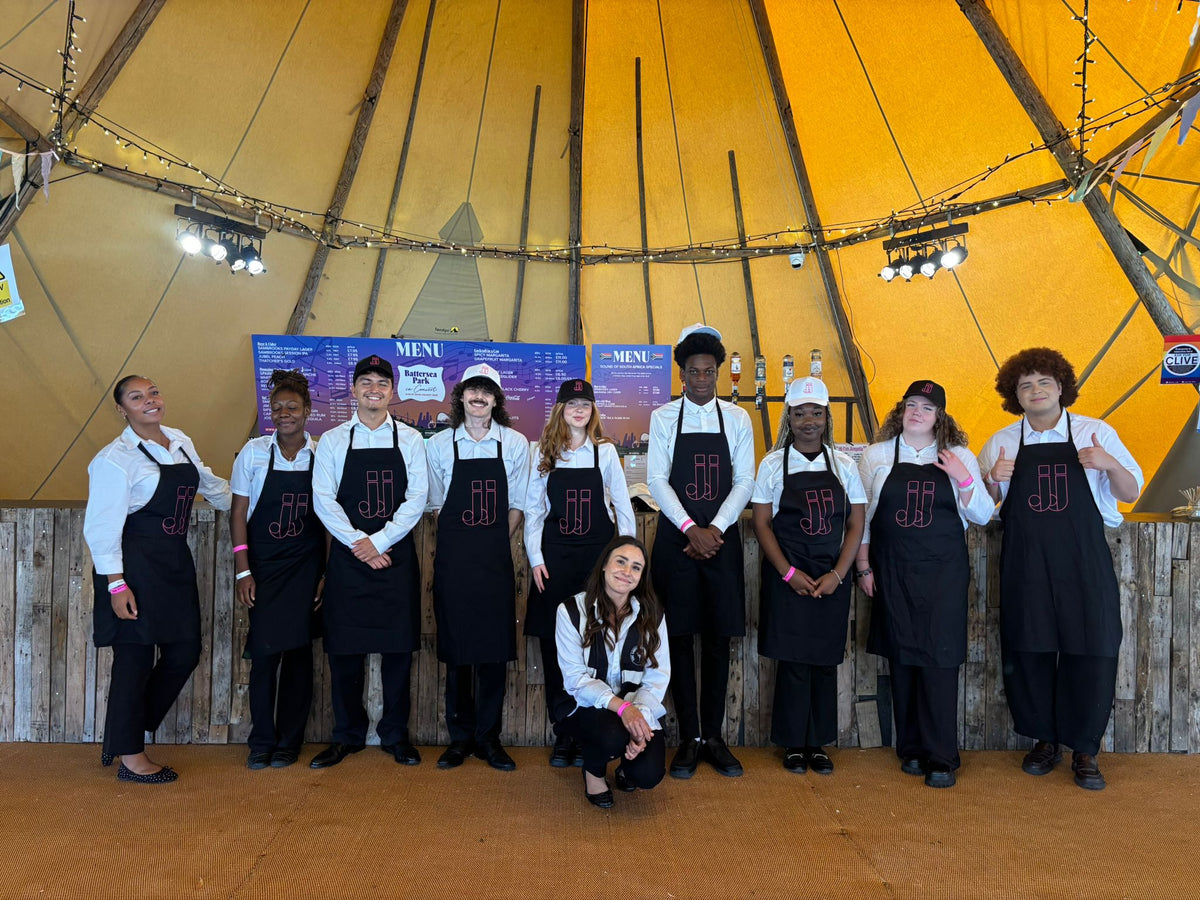 The Domaine des Jeanne festival team lined up in black aprons in the tipi at CarFest