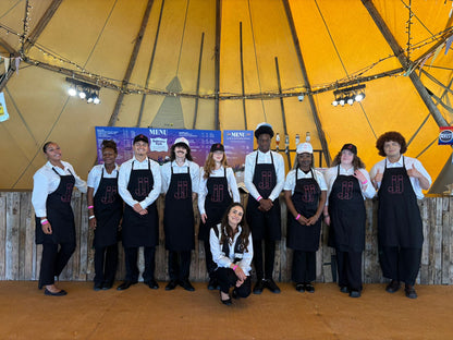 The Domaine des Jeanne festival team lined up in black aprons in the tipi at CarFest